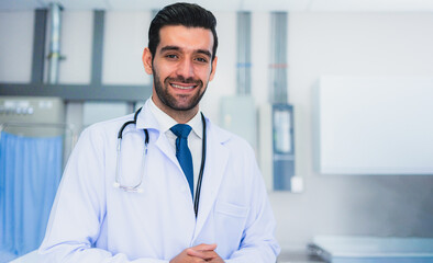 Portrait of Male caucasian medical doctor with stethoscope wearing white coat standing In modern hospital.