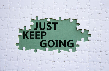 Just keep going symbol. White puzzle with words Just keep going. Beautiful grey green background....