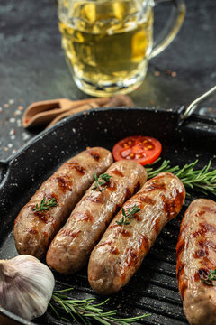 Grilled german bratwurst sausages with rosemary herbs on the grill pan. vertical image. top view. place for text