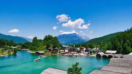 Smaragdgrüner Königsee mit Elektroboot, Anlegestegen und Bootshäusern