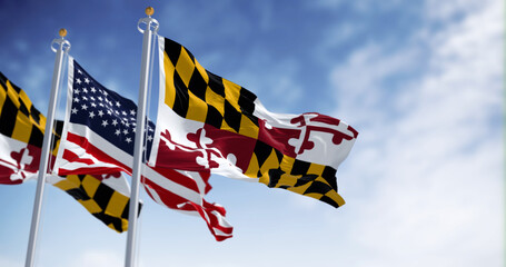 Flags of Maryland and of the United states waving in the wind on a clear day