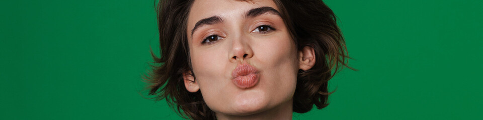 Obraz premium Young woman making kiss lips while holding copyspace