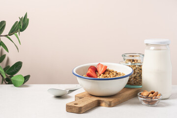 Granola in bowl with strawberries on light background with copy space. Food breakfast background