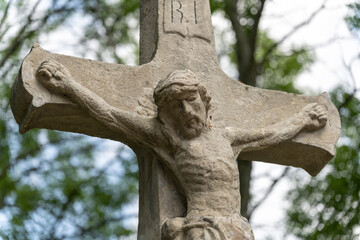 Stone cross with Jesus outside.