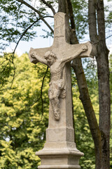 Stone cross with Jesus outside.