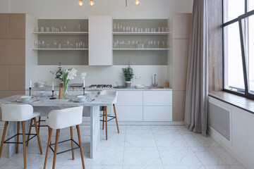 close view kitchen with dinning marble table and hight bar stools in minimalistic light elegant luxury design of a modern spacious studio apartment in soft pastel beige colors
