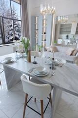 minimalistic light elegant luxury design of a modern spacious studio apartment with kitchen area, bedroom and huge mirror behind the couch. tiles on the floor and high ceiling.