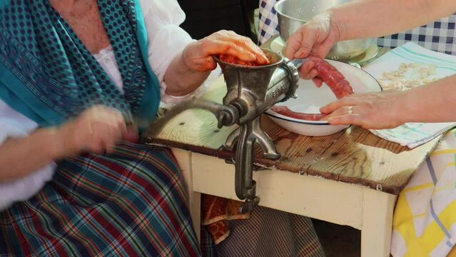 Women making chorizos with meat from the slaughter in a traditional way in Spain