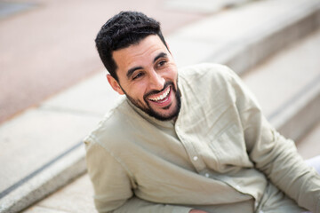 Handsome young middle eastern man laughing outside