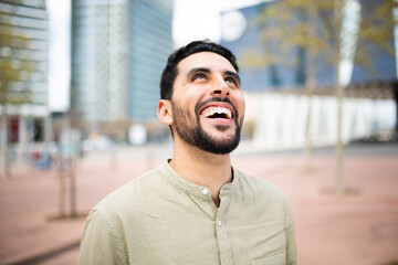 Carefree young arabic man laughing outside