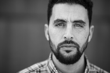 Close up of serious young arabic man staring at camera