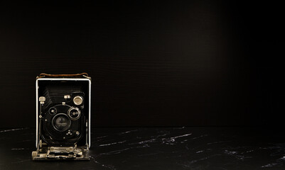Ancien appareil photo vintage à soufflet sur fond noir - appareil analogique 