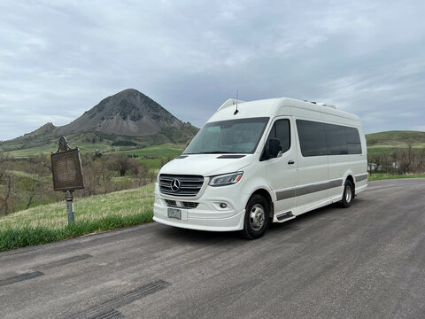A Van in front of Bear Butte in Bear Butte State Park near Sturgis, South Dakota on a cloudy day.