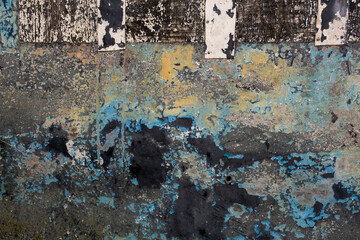 Old metallic panel with scraps of flaking paint layers, grunge background
