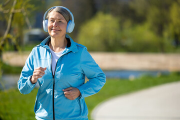 Smiling woman in blue blazer running in the park
