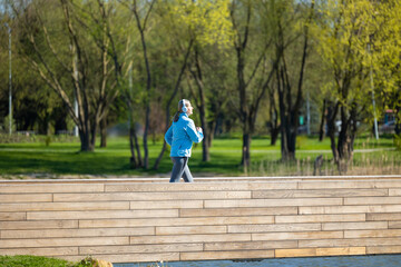 Woman in blue blazer running in the park in the morning