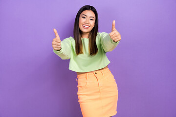 Photo of nice confident lady wear green sweatshirt smiling showing two thumbs up isolated purple color background
