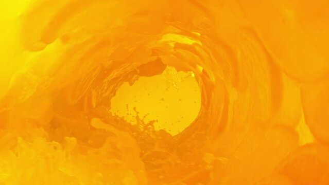 Super slow motion of mixing orange juice in twister shape. Filmed on high speed cinema camera, 1000 fps.