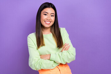Fototapeta premium Photo of confident cheerful lady wear green sweatshirt arms crossed empty space isolated purple color background