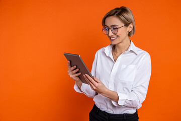 Smiling woman wearing white official style shirt using tablet online communication