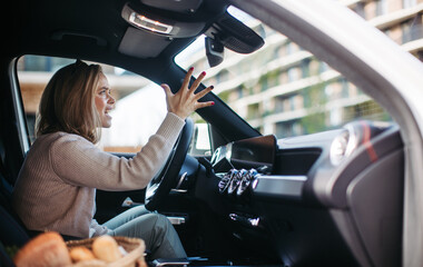 Upset woman driving her car in a city.