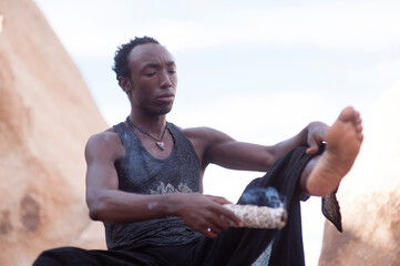 Photographs of a young black gay man practicing Reiki in the desert.  - 619525082
