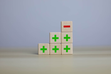 wooden blocks with plus and minus signs Comparatively opposite concepts Analyze differences to decide the positive or negative business options of the strategy.
