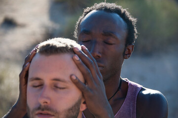 Photographs of a young black gay man practicing Reiki in the desert. 