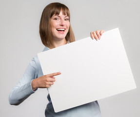 Young happy woman with an empty advertising board ready for lettering