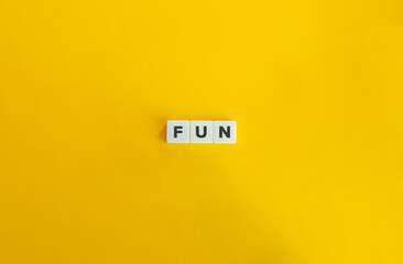 Fun Word on Block Letter Tiles on Yellow Background. Minimal Aesthetic.