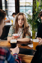 Friends hands toasting and having fun together drinking beer and cocktails at happy hour in pub restaurant . Social life style party time concept