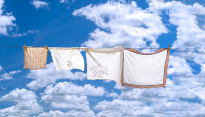 Fresh hung laundry against a blue sky and clouds.