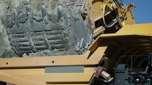 Loading the rock in dumper large quarry truck to transport ore from open-pit, slow motion