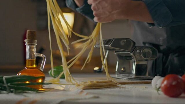 Handmade, chef baker prepares In authentic pasta workshop. Close-up of a male baker preparing dough, sifting flour and adding ingredients uses all the advantages of home cooking, technique
