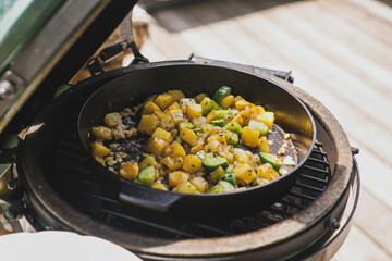 ready to eat - roasted potatoes and eggs from a charcoal grill, cooked on the balcony at a sunny summer day