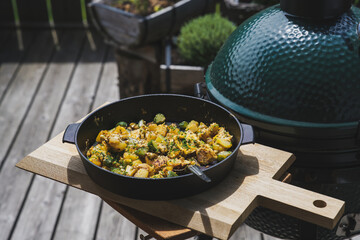 ready to eat - roasted potatoes and eggs from a charcoal grill, cooked on the balcony at a sunny summer day