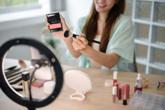 Female beauty blogger Influencer filming cosmetics makeup or comparing review on live stream..
