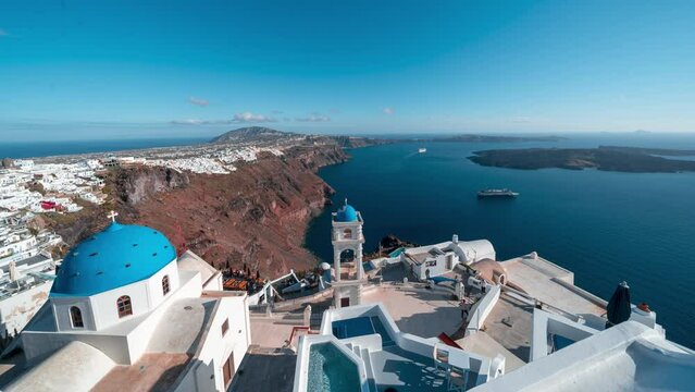 Time lapse of golden hour with view on white and blue church with view on the caldera cliff and cruise ships on the Greek island of Santorini