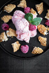 Obraz na płótnie Canvas Raspberry ice cream in a bowl. on a dark background. Sweet dessert