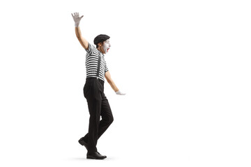 Full length profile shot of a mime walking and balancing