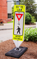 yellow pedestrian sign stands tall on a busy street, symbolizing safety, caution, and the...