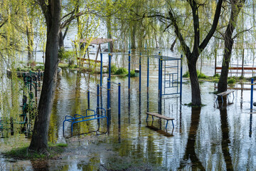 Flood on bank river in spring time. Water filled play and sport grounds in city. Overflowed bank...