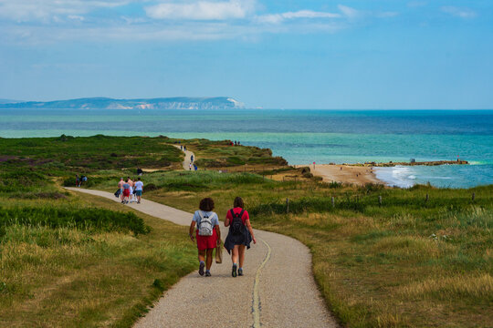 Warren Hill, Hengistbury Head, UK - July 1st 2023: People on the footpath overlooking the Long Groyne on the beach.