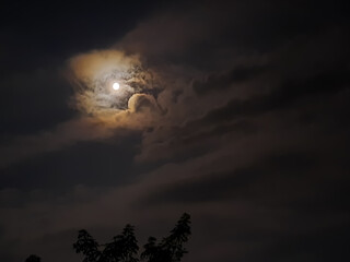 amazing cloudy sky and the moon behind it , July,3,2023 : Rampur Uttar Pradesh India.