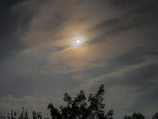 amazing cloudy sky and the moon behind it , July,3,2023 : Rampur Uttar Pradesh India.