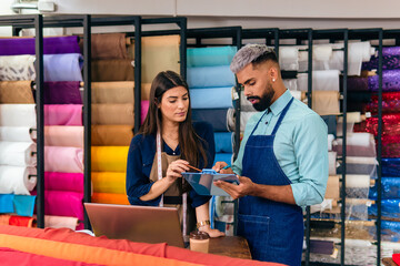african american salesman presenting inventory and business information to colleague at fabric store
