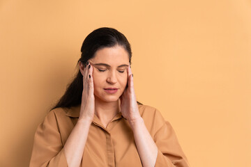 unhappy caucasian woman with hands over the face in all beige colors. frustration, unhappy, problem concept.