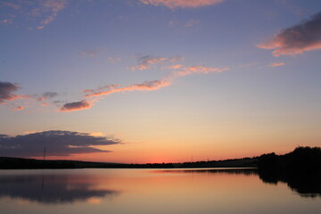 A body of water with a sunset in the background