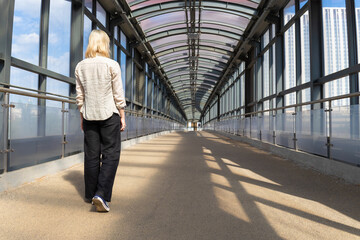 Moscow, Russia - June 18, 2023: a girl walks alone along an overpass.