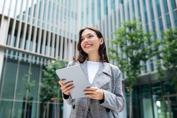Smiling Business Lady Using Tablet Computer Standing In Urban Area